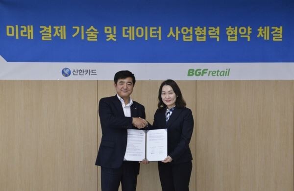 ▲김윤경 BGF리테일 마케팅실장(오른쪽)이 협약 체결 후 이찬홍 신한카드 그룹장이 악수하고 있다. [사진=BGF리테일]