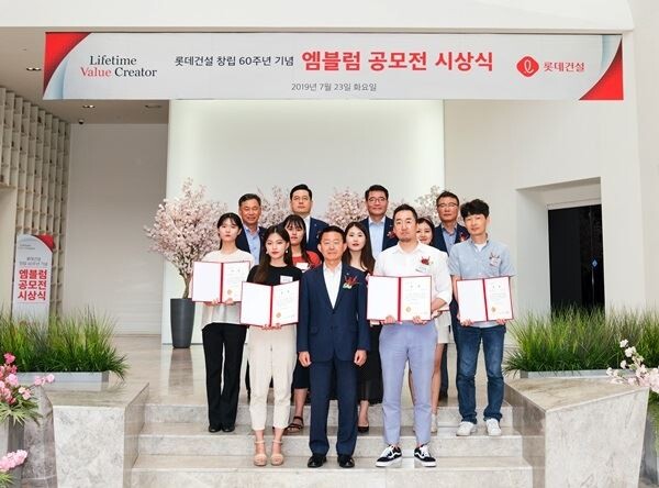 롯데건설 창립 60주년 기념 엠블럼 공모전 시상식에서 롯데건설 하석주 대표이사(첫 번째 줄 가운데)와 임직원 및 수상자들이 기념촬영 중이다. (사진제공=롯데건설)