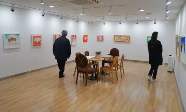 유디치과(강남뱅뱅 유디치과의원)를 찾은 환자들이 유디갤러리에서 작품을 관람하고 있다.[사진제공=유디치과]