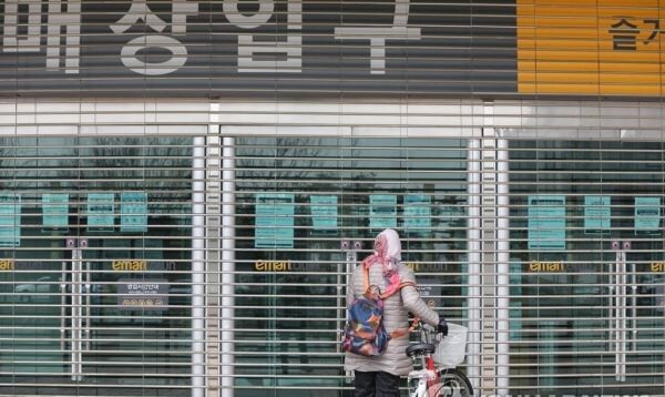21일 오전 경기 고양 일산 이마트타운 킨텍스점 입구에서 한 주민이 임시휴점 안내문을 읽고 있다.[사진=연합뉴스]
