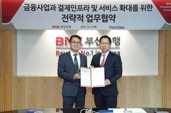 BNK부산은행 한정욱 디지털금융본부장(왼쪽)과 퍼스트데이터코리아 김종윤 대표가 협약 체결 후 기념사진을 찍고 있다.[사진 = 부산은행 제공]