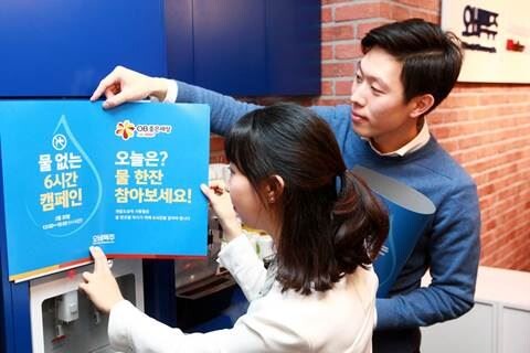 ▲지난 20일 오비맥주 직원들이 ‘세계 물의 날’을 기념해 서울 삼성동 본사에서 ‘물 없는 6시간’ 캠페인 포스터를 부착하고 있다. [사진=오비맥주]