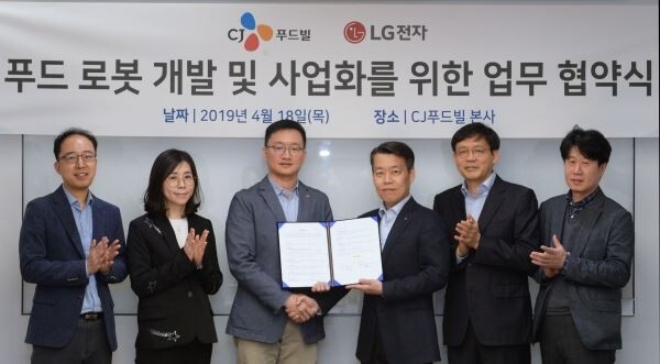 ▲CJ푸드빌과 LG전자는 18일 을지로 CJ푸드빌 본사에서 '푸드 로봇 개발 및 사업화를 위한 양해각서(MOU)'를 체결하고 상호 교류 협력하기로 했다. (사진에서 왼쪽 세 번째) CJ푸드빌 전략기획담당 오광석 헤드, (오른쪽 세번째) LG전자 로봇사업센터장 노진서 전무. [사진=CJ푸드빌]
