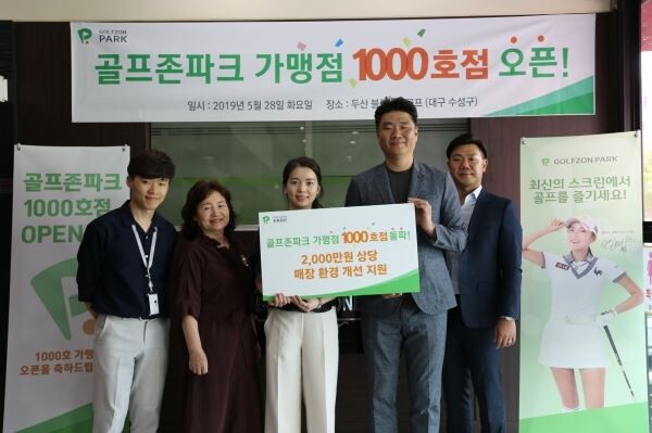 골프존파크 가맹점 1000호 매장 두산 블랙스톤점의 김애현 대표(가운데)와 골프존 영남사업팀 황윤 팀장(우측 두 번째) 및 관계자들이 1천호점 달성 기념촬영을 하고 있다.[사진제공=골프존]