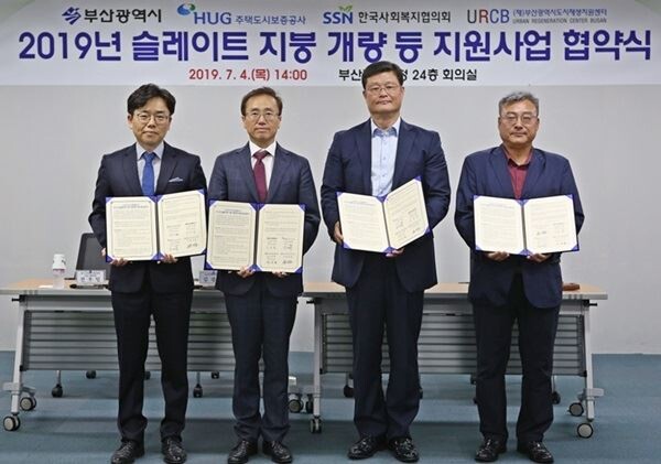 김광회 부산광역시 도시재생균형국 국장(왼쪽에서 두 번째), 김태복 HUG 부사장(왼쪽에서 세 번째), (순서대로) 전우일 한국사회복지협의회 나눔기획실장, 변강훈 (재)부산광역시 도시재생지원센터 원장이 ‘2019년 슬레이트 지붕 개량 등 지원사업 협약식’을 갖고 기념촬영을 하고 있다.