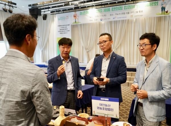 ▲편의점 세븐일레븐은 지난 11일 서울 더케이호텔에서 편의점 입점을 위한 농촌융복합산업 상품 품평회를 개최했다. 품평회에 참석한 (오른쪽부터) 김신재 농림축산식품부 농촌산업과장, 오재용 세븐일레븐 상품부문장, 김선호 한국농어촌공사 농어촌자원개발원장이 업체 관계자로부터 상품 설명을 듣고 있다. [사진=코리아세븐]