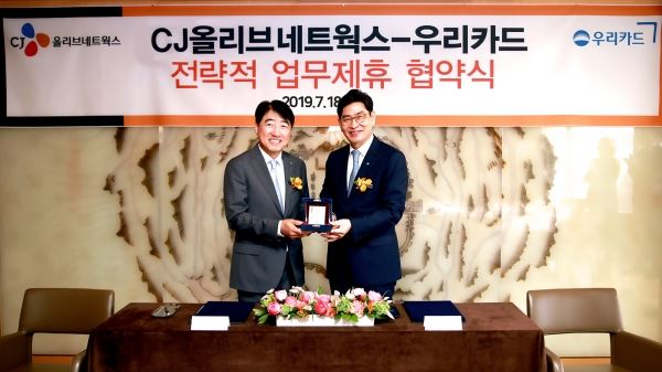 ▲18일 진행된 우리카드-CJ올리브네트웍스 업무제휴 협약식에서 정원재 우리카드 사장(오른쪽)이 이경배 CJ올리브네트웍스 대표이사에게 감사카드를 전달하며 기념촬영을 하고 있다. [사진=우리카드]