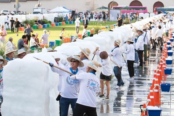 ▲10일 광화문광장에서 크라운해태 임직원 300여명이 '2019 한여름밤의 눈조각전'에 전시할 작품을 만들고 있다. [사진=크라운해태]