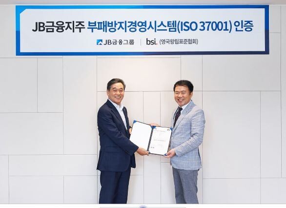 JB금융그룹 김기홍 회장(왼쪽)이 BSI 코리아 송경수 총괄 책임으로부터 지난 30일 서울 여의도 JB빌딩에서 'ISO 37001' 인증서를 수여받고 있다.[사진제공=JB금융지주]