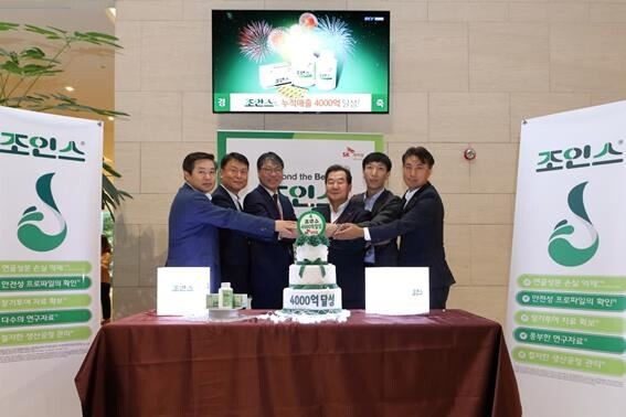 SK케미칼 전광현 사장(사진 우측 세 번째)이 구성원들과 함께 조인스정 누적매출 4천억 돌파 기념 세레머니에서 포즈를 취하고 있다.[사진제공=SK케미칼]