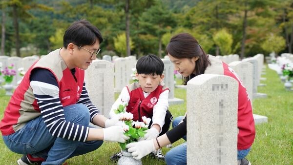 롯데건설 임직원 가족들이 현충문 앞에서 봉사활동 기념촬영을 하고 있다.[사진제공=롯데건설]