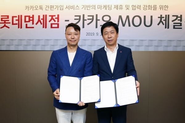 ▲지난 25일 롯데면세점 본사 대회의실에서 이갑 롯데면세점 대표이사(사진 오른쪽)와 신석철 카카오 부사장이 ‘카카오톡 간편가입 서비스 기반의 마케팅 제휴 및 협력 강화를 위한 업무협약’ 체결식을 진행하고 있다. [사진=롯데면세점]