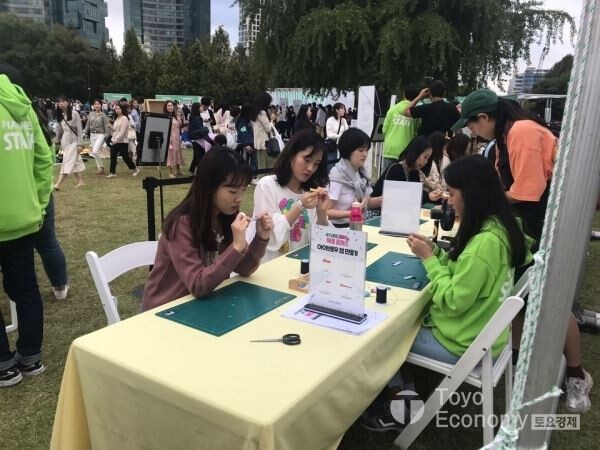 ▲이니스프리의 친환경 페스티벌 '2019플레이그린'에서 아이브로우 캡 만들기를 하고 있는 참가자들. [사진=김자혜 기자]