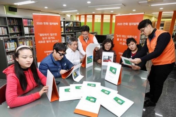 한화그룹이 시각장애인들을 위한 점자달력 4만부를 제작해 무료로 배포한다. 2020년 탁상용 점자달력에는 시각장애인들이 세상에 전하 고 싶은 메시지를 글과 점자로 표현했다. 인천광역시에 위치한 혜광 학교에서 이료재활과정을 이수중인 시각장애인들이 내년도 점자달력 을 읽고 있다.[사진제공=한화그룹]