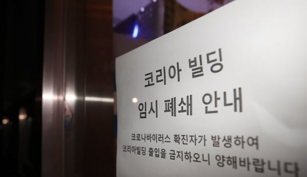 서울 구로구 신도림동 코리아빌딩 11층에 있는 콜센터에서 집단 감염 사례로 추정되는 코로나19 확진자가 무더기로 발생했다고 구로구가 밝힌 9일 해당 건물 앞에 임시 폐쇄 관련 안내문이 붙어 있다.[사진=연합뉴스]